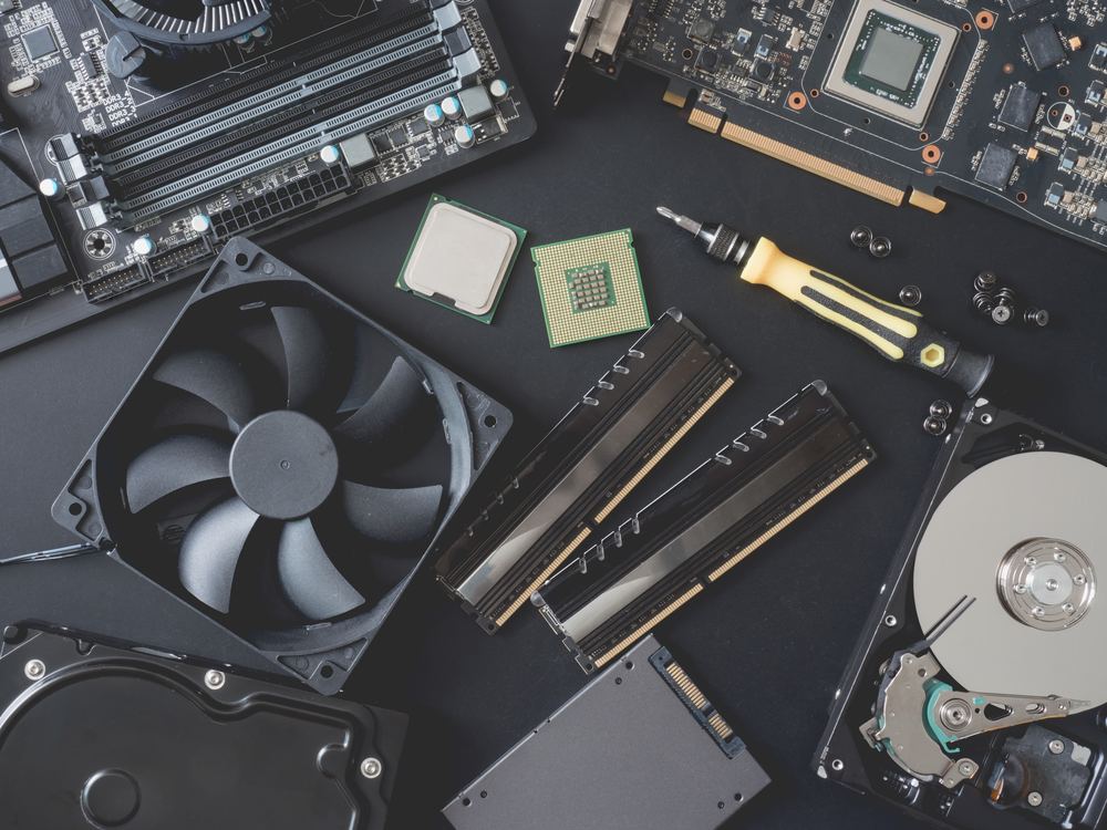 Computer parts on a bench: cooling fan, memory, hard drive and processor